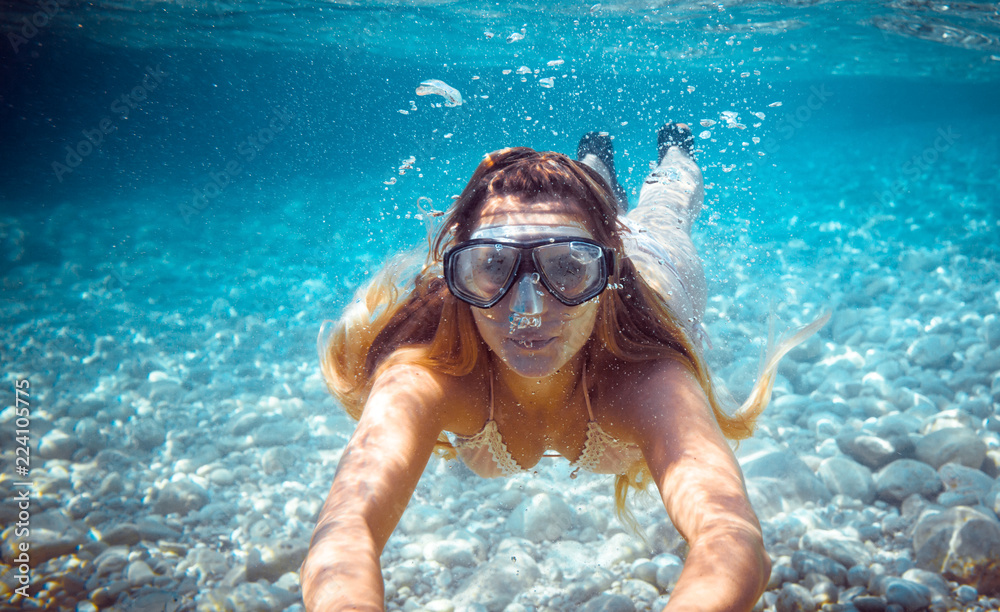 Girl snorkeling underwater in the tropical sea