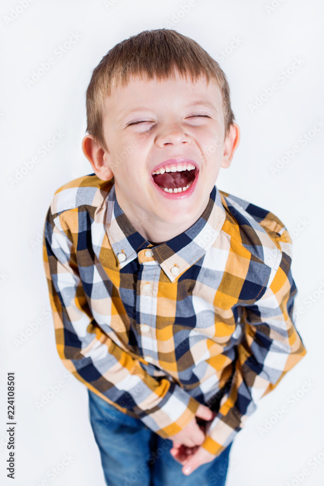 Little boy in plaid shirt on white background laughing cheerfully. Little boy in plaid shirt on white background laughing cheerfully.