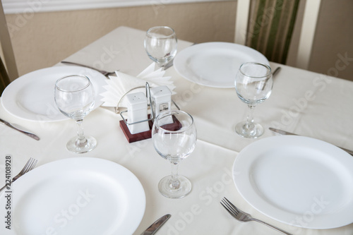 Glasses and glasses for wine on a table with a white tablecloth in a restaurant © nidvoray