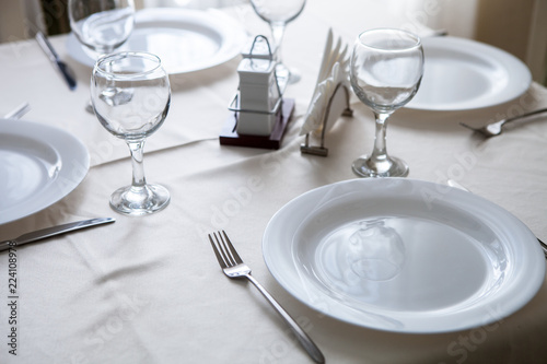 Glasses and glasses for wine on a table with a white tablecloth in a restaurant