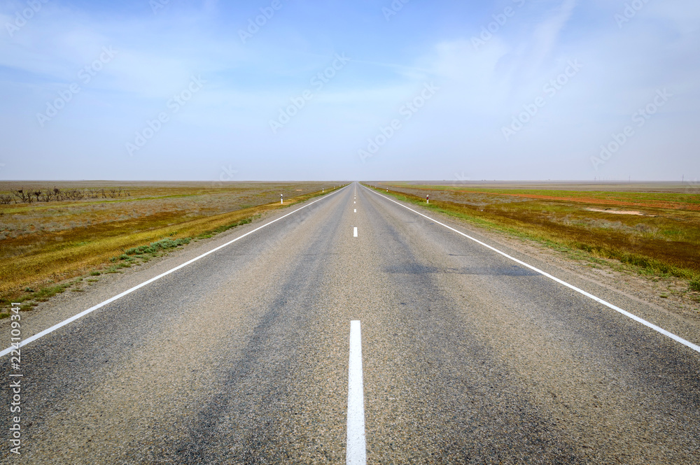 The picturesque landscape and blue sky over road. Asphalt road with marking