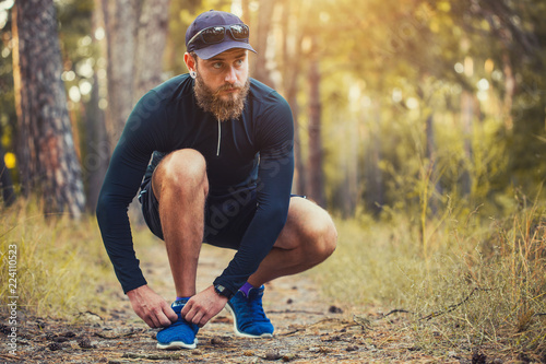 A bearded athleteties up the shoelaces. healthy lifestyle concept