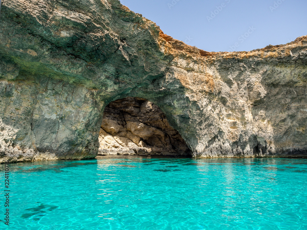 Felsenhöhle mit aquamarin farbenem Meer und blauem Himmel in der Sonne, Gozo, Malta