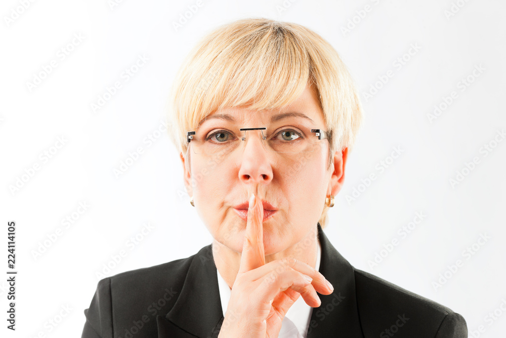 Blonde mature businesswoman putting finger on her lip isolated over white background Blonde mature businesswoman putting finger on her lip isolated over white background