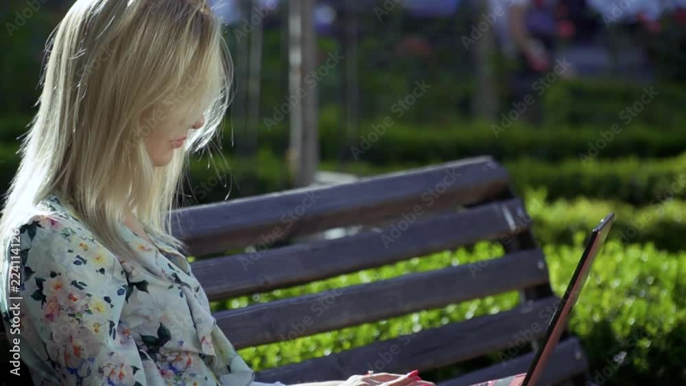 Beautiful girl is sitting on a bench in the park Beautiful girl is sitting on a bench in the park