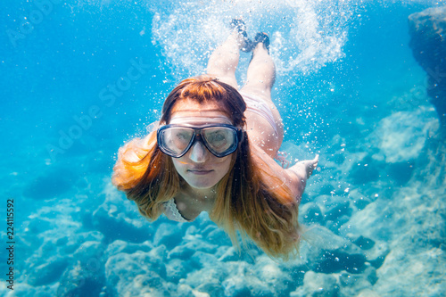 Young woman snorkeling underwater in the clear tropical water