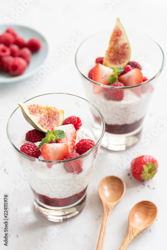 Chia seed pudding in glass with fresh berries on white background. Closeup view, selective focus. Healthy eating, healthy lifestyle concept