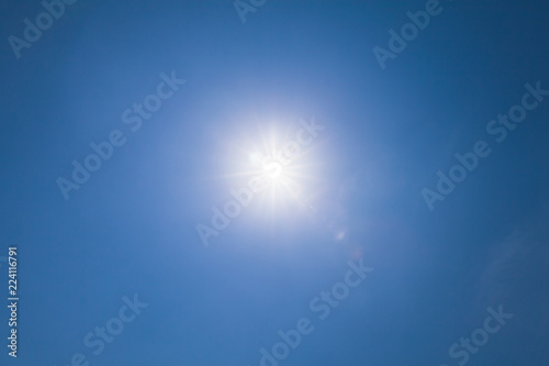 Lens flare effect over blue sky with sunlight