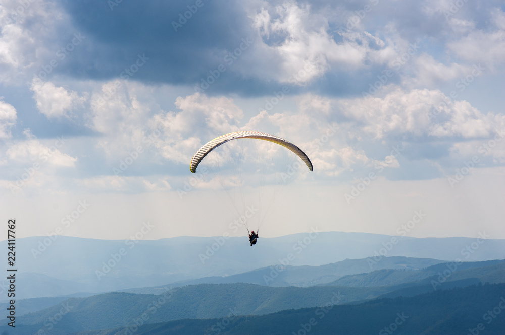 Paraglider takes off from the mountainside in the Carpathian Mountains. Paragliding in the mountains in the summer. Paraglider takes off from the mountainside in the Carpathian Mountains. Paragliding in the mountains in the summer.