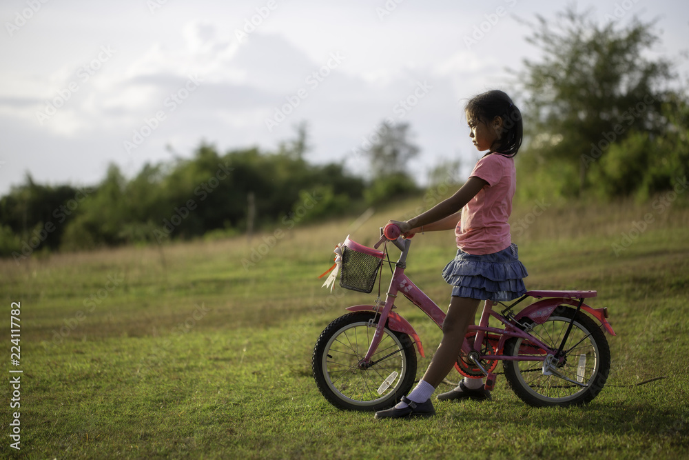 A female schoolchild fun with bicycle in the park. A female schoolchild fun with bicycle in the park.