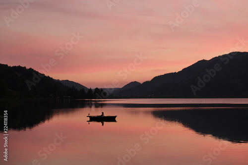 Angler am See nach Sonnenuntergang bei Abendstimmung