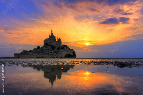 Beautiful view of historic landmark Le Mont Saint-Michel in Normandy  France  a famous UNESCO world heritage site and tourist attraction  at sunset with reflection