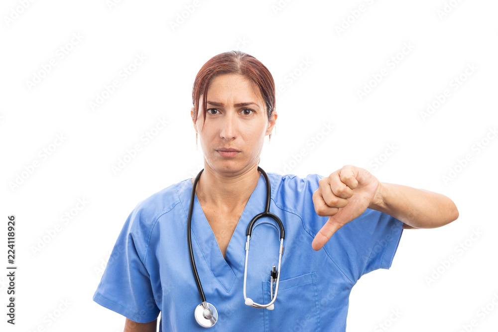 Upset female woman nurse or doctor making thumbs down gesture .