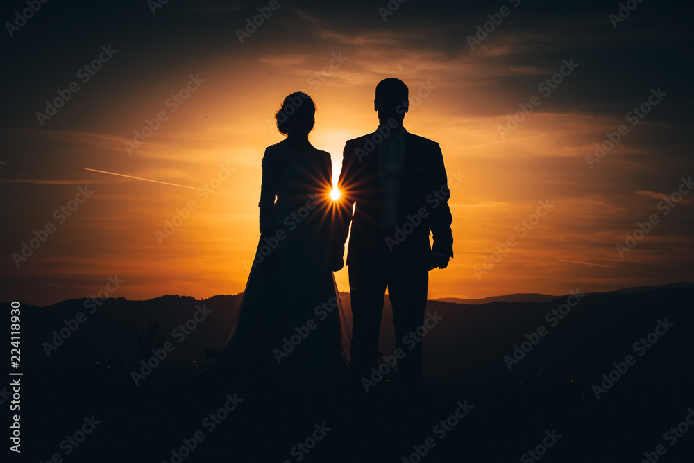 Man and woman silhouette, beautiful sun ray in the middle
