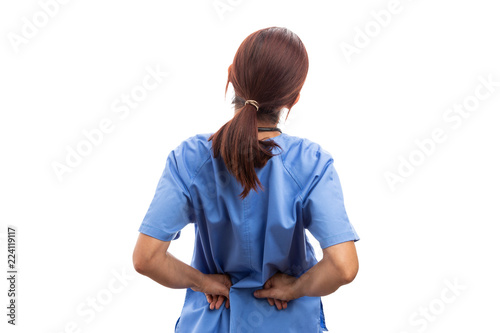 Rear view of female nurse or doctor holding painful lumbar area.
