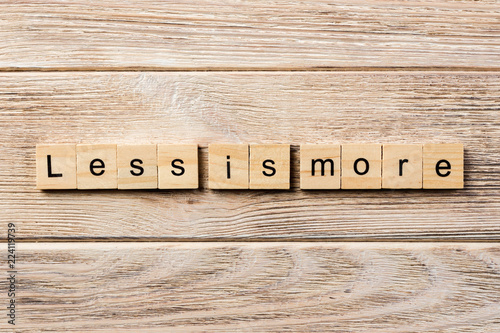 less is more word written on wood block. less is more text on table, concept photo