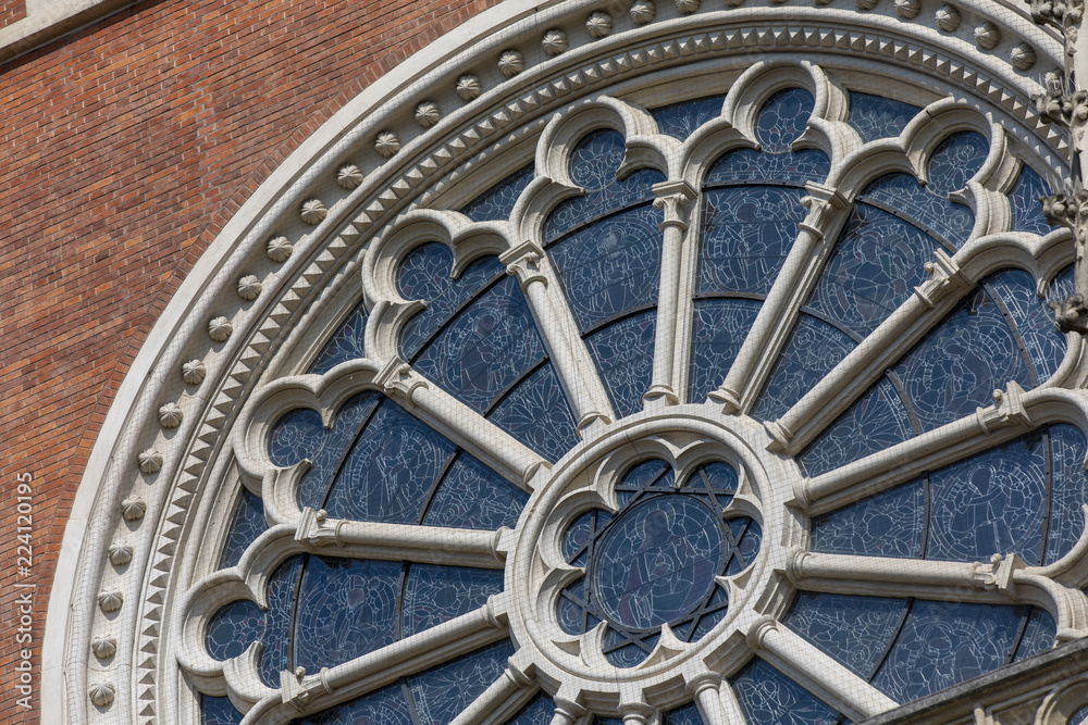 rosette or circular window filled with stained glass and ornamentation in the facade of neogothic Church of the Sacred Heart of Jesus, Graz,Austria