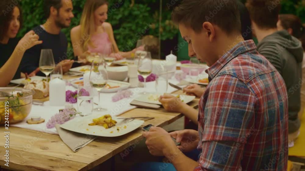 Man is on phone while dinner party outside Man is on phone while dinner party outside