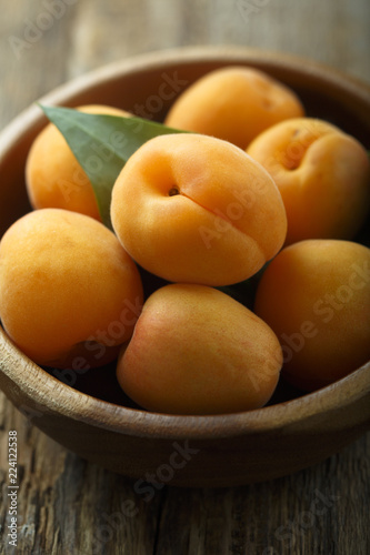 Fresh apricots in the wooden bowl