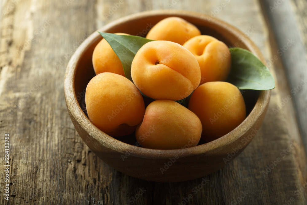 Fresh apricots in the wooden bowl