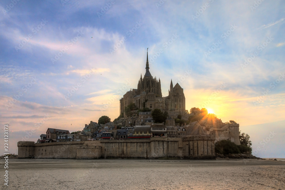 Beautiful view of historic landmark Le Mont Saint-Michel in Normandy, France, a famous UNESCO world heritage site and tourist attraction, at sunset