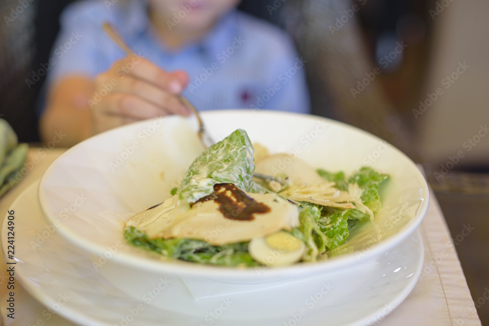 little boy eating salad in cafe little boy eating salad in cafe