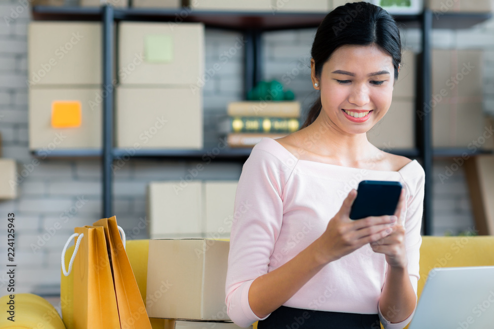 Young Asian beautiful girl is happy smiling to shopping online with smartphones and other order items she buys around her. Concept technology makes us live more comfortable and easy to tread Young Asian beautiful girl is happy smiling to shopping online with smartphones and other order items she buys around her. Concept technology makes us live more comfortable and easy to tread