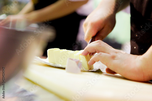 chef cutting butter in kitchen, Cutting butter with a knife in closeup