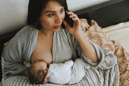Photography Mother breastfeeding while on the phone