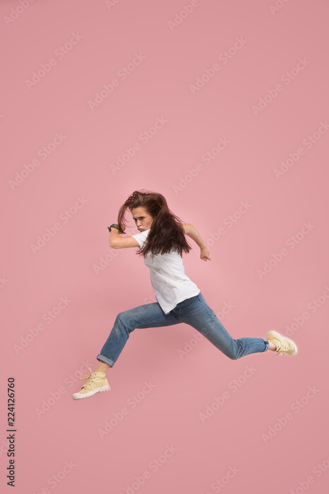 What is there interesting in the distance. seeking pretty happy young woman jumping and grabbing against pink studio background. Runnin girl in motion or movement. Human emotions and facial What is there interesting in the distance. seeking pretty happy young woman jumping and grabbing against pink studio background. Runnin girl in motion or movement. Human emotions and facial