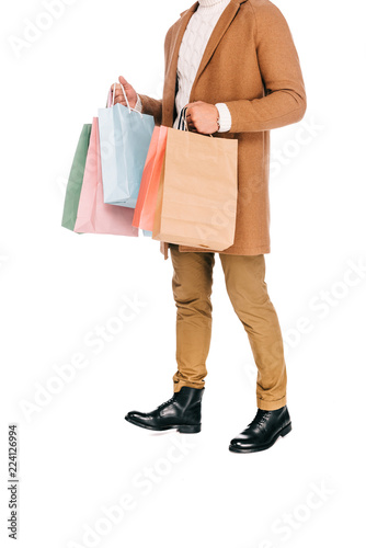 cropped shot of young man holding shopping bags isolated on white