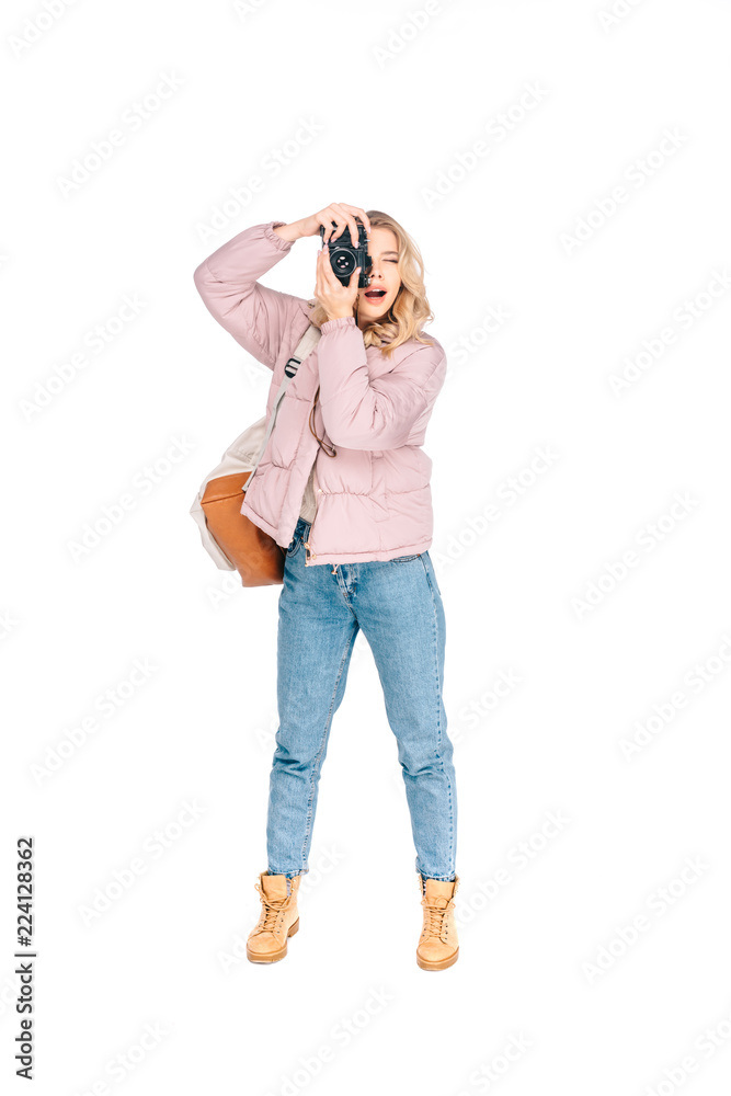 full length view of young woman with backpack photographing with camera isolated on white full length view of young woman with backpack photographing with camera isolated on white