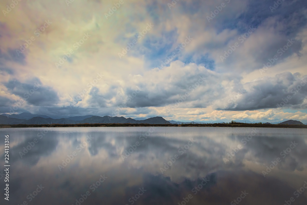 Mountain lake in Austria Alps with reflection of dramatic sky. Nature background.