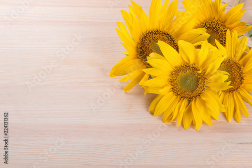 Bouquet of beautiful yellow sunflowers on a natural wooden background with a place for inscription