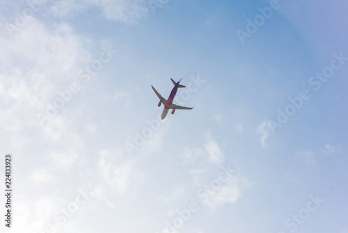 low angle view of plane flying in blue cloudy sky