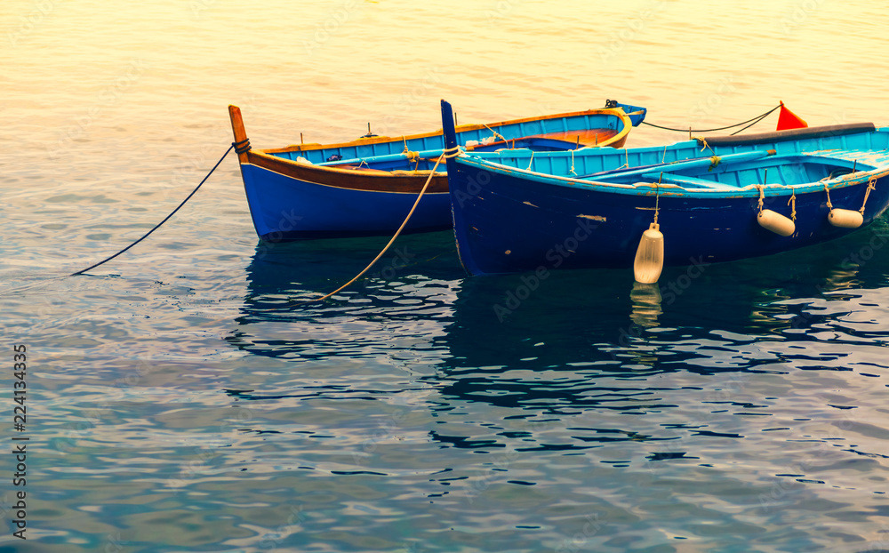 Two small boats moored together on Mediterranean sea.