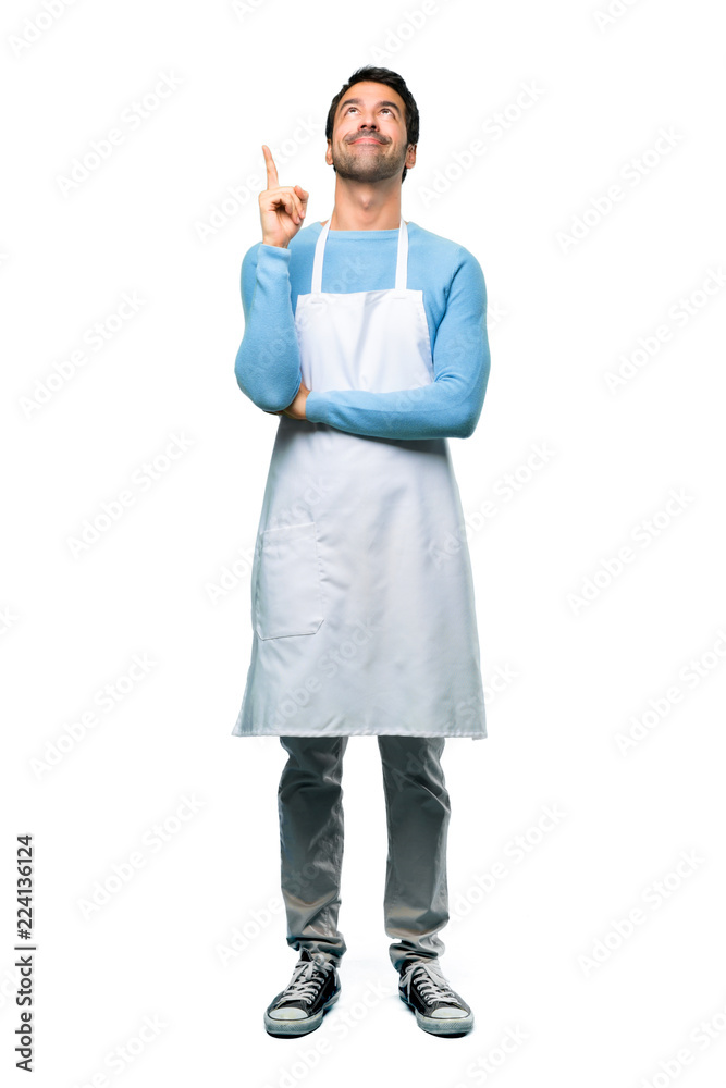 A full-length shot of a Man wearing an apron pointing with the index finger a great idea and looking up on isolated background