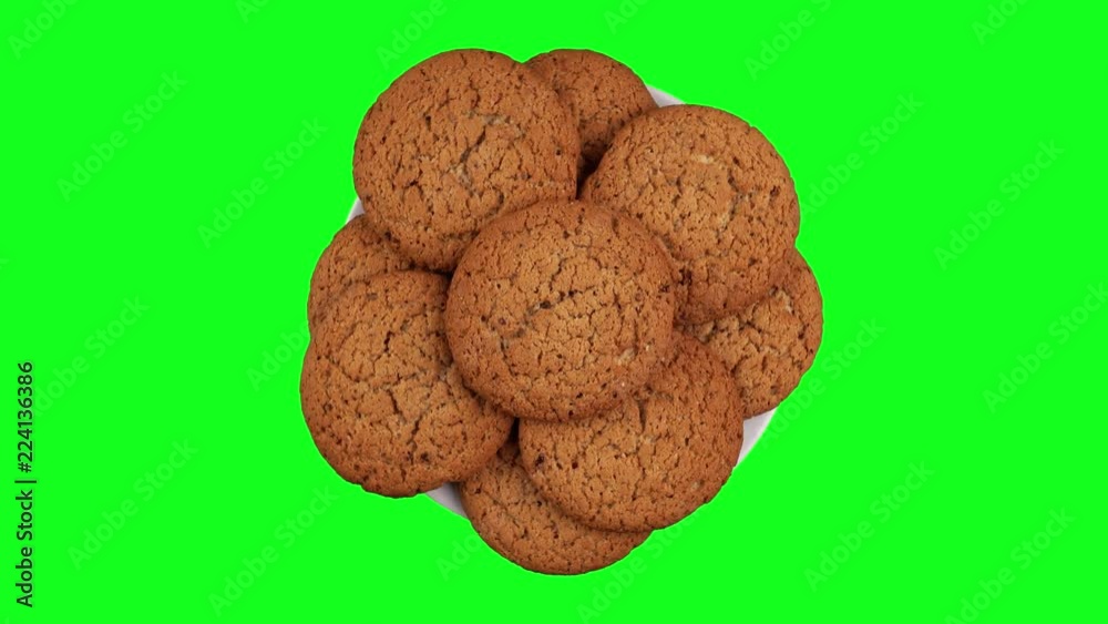 A stack of cookies rotates. A few biscuits on a rotating plate. A white plate on a Green screen.