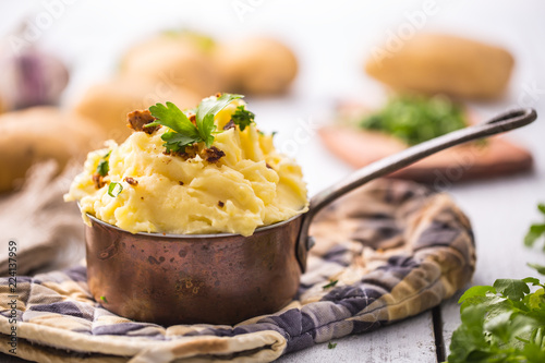 Mashed potatoes in pan decorated with parsley herbs.