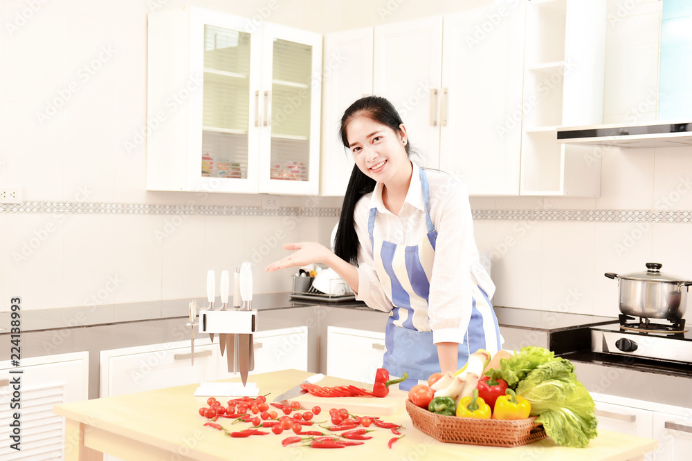 Asian housekeeper smiles in modern kitchen