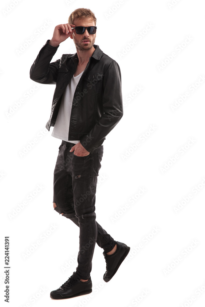 relaxed handsome man steps to side and fixes sunglasses relaxed handsome man steps to side and fixes sunglasses