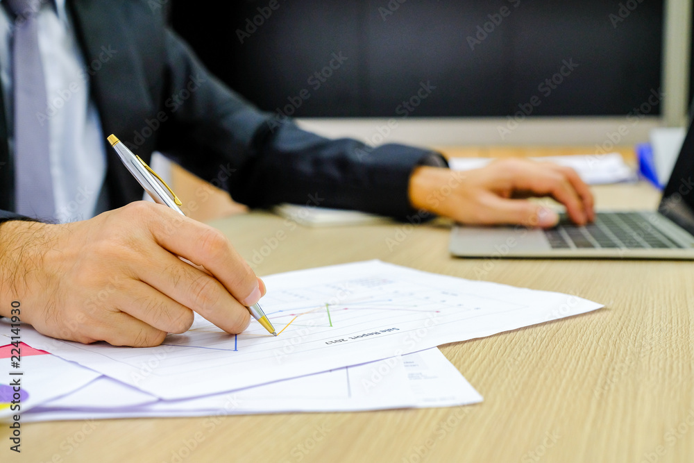 Businessman using red pen writing in notepad on office table Businessman using red pen writing in notepad on office table