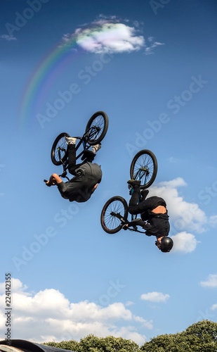 Young men doing tricks in the air on a BMX bikes. BMX riders