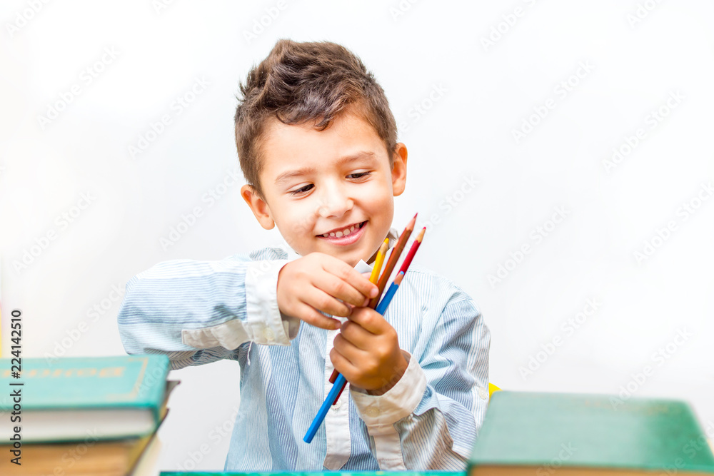 brown-eyed boy in a shirt with pencils surrounded by books brown-eyed boy in a shirt with pencils surrounded by books