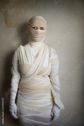 Fototapet woman wrapped in bandages as egyptian mummy halloween costume