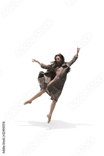Fototapeta Naklejka Na Ścianę i Meble -  Beautiful slim young female modern jazz contemporary style ballet dancer in silhouette wearing beige long cloak isolated on a white studio background