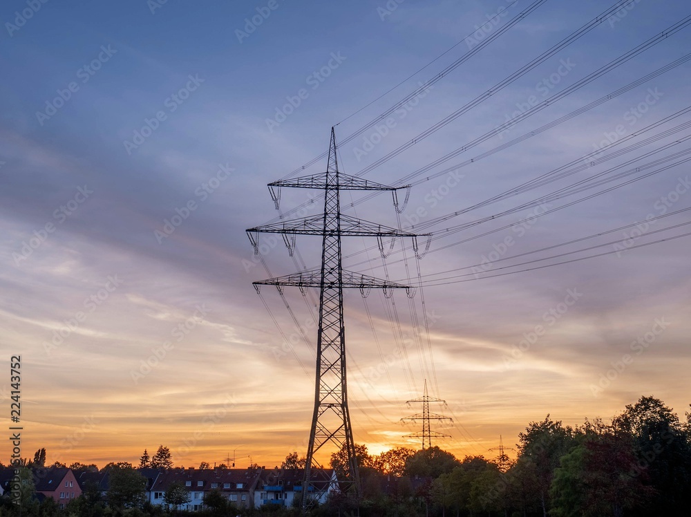 Stromleitung nahe Wohngebiet bei Sonnenuntergang