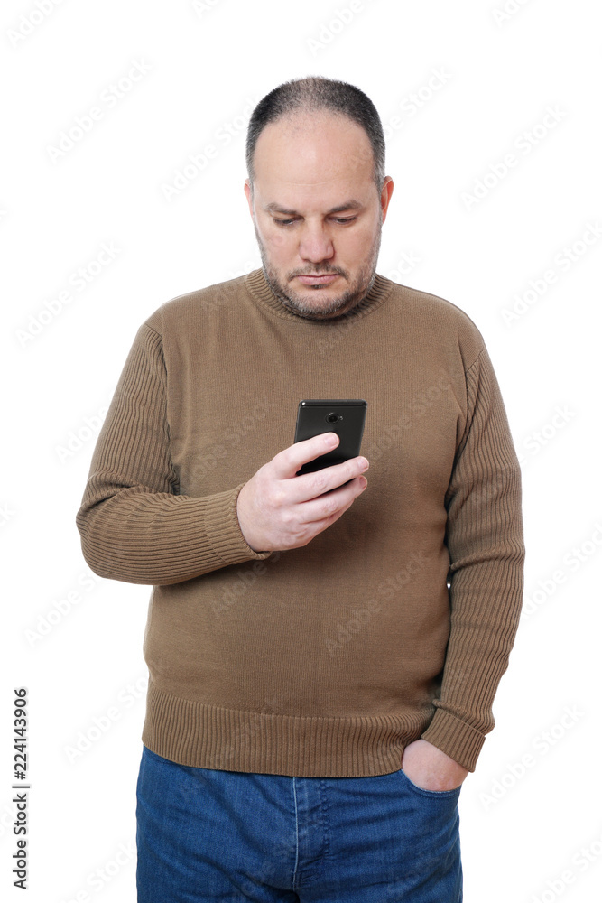 middle aged man looking down at his mobile smart phone middle aged man looking down at his mobile smart phone