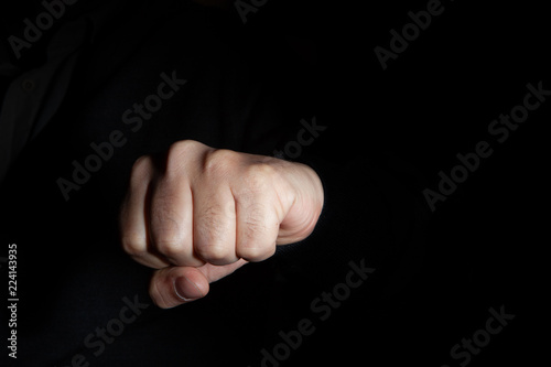 Power concept, close up fist in  a black background