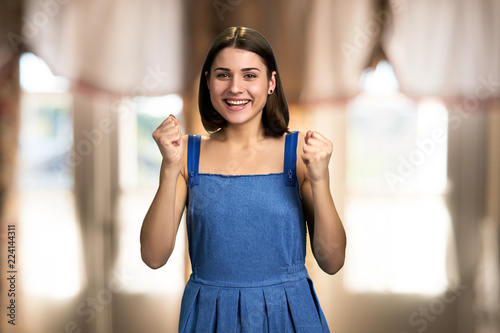 Young excited woman on blurred background. Portrait of happy ecstatic winning girl clenched fists hand celebrating the victory. Free Download Young excited woman on blurred background. Portrait of happy ecstatic winning girl clenched fists hand celebrating the victory. - GFXLoad
